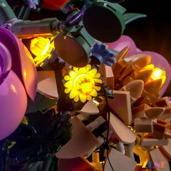 Detailed view of yellow LED lights illuminating flower components in the LEGO Pretty Pink Flower Bouquet #10342 light kit.